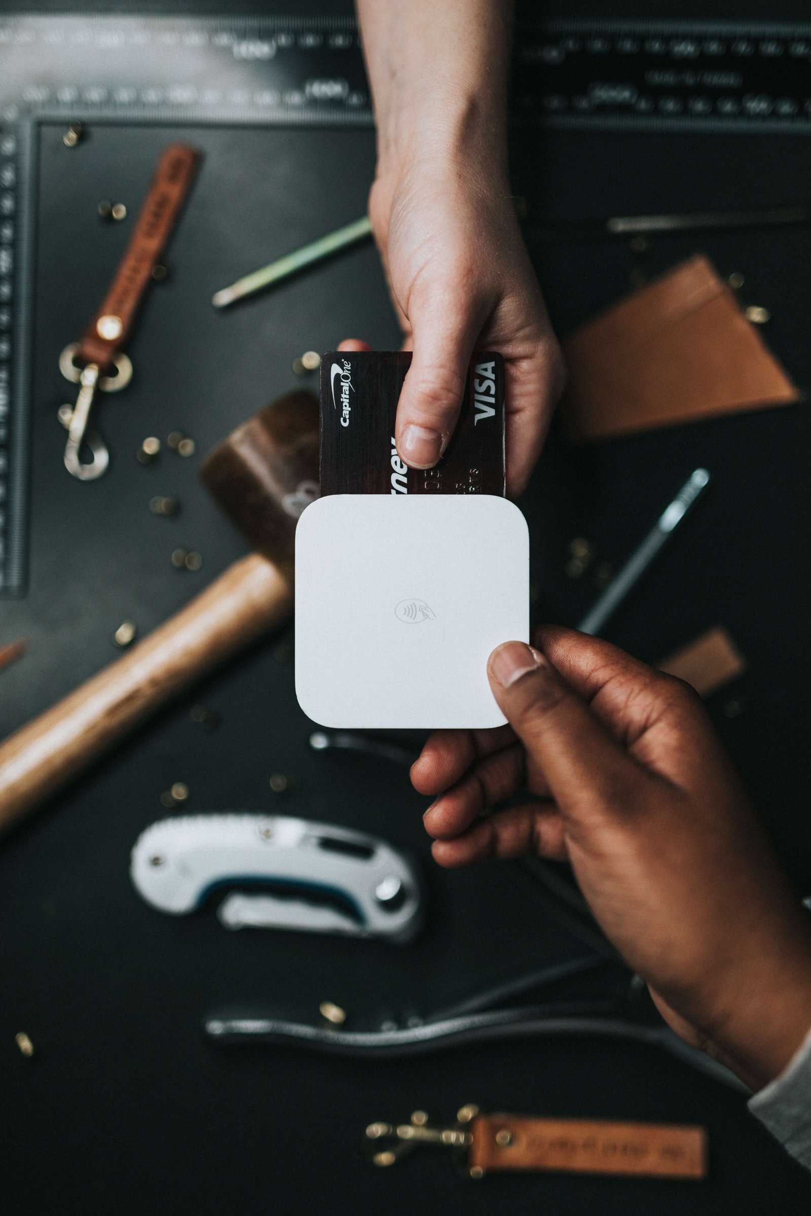 person holding visa card and white device, showing fintech concept