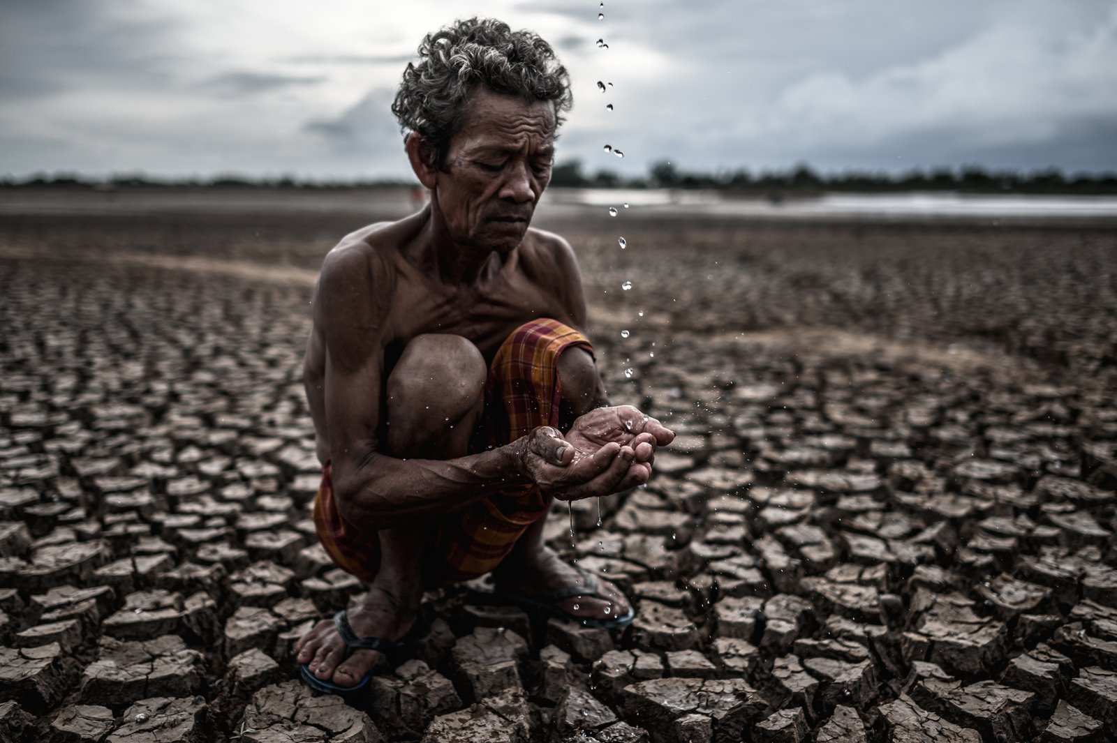 Farmer sitting on the barren land