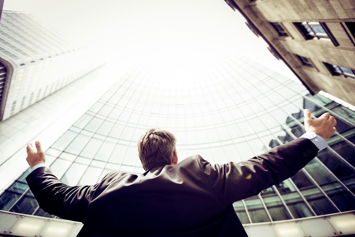 Man showing satisfaction over business expansion and success in front of commercial building