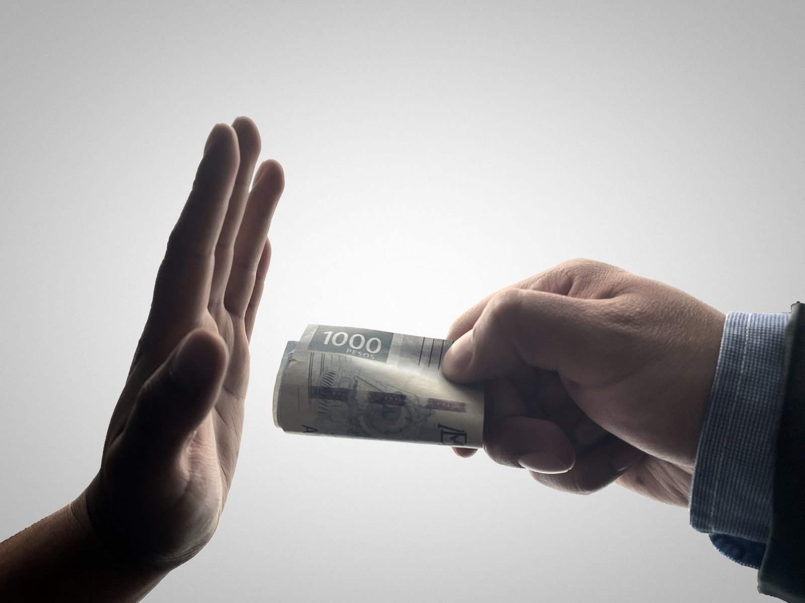 Showing a man hand stoping other from bribery